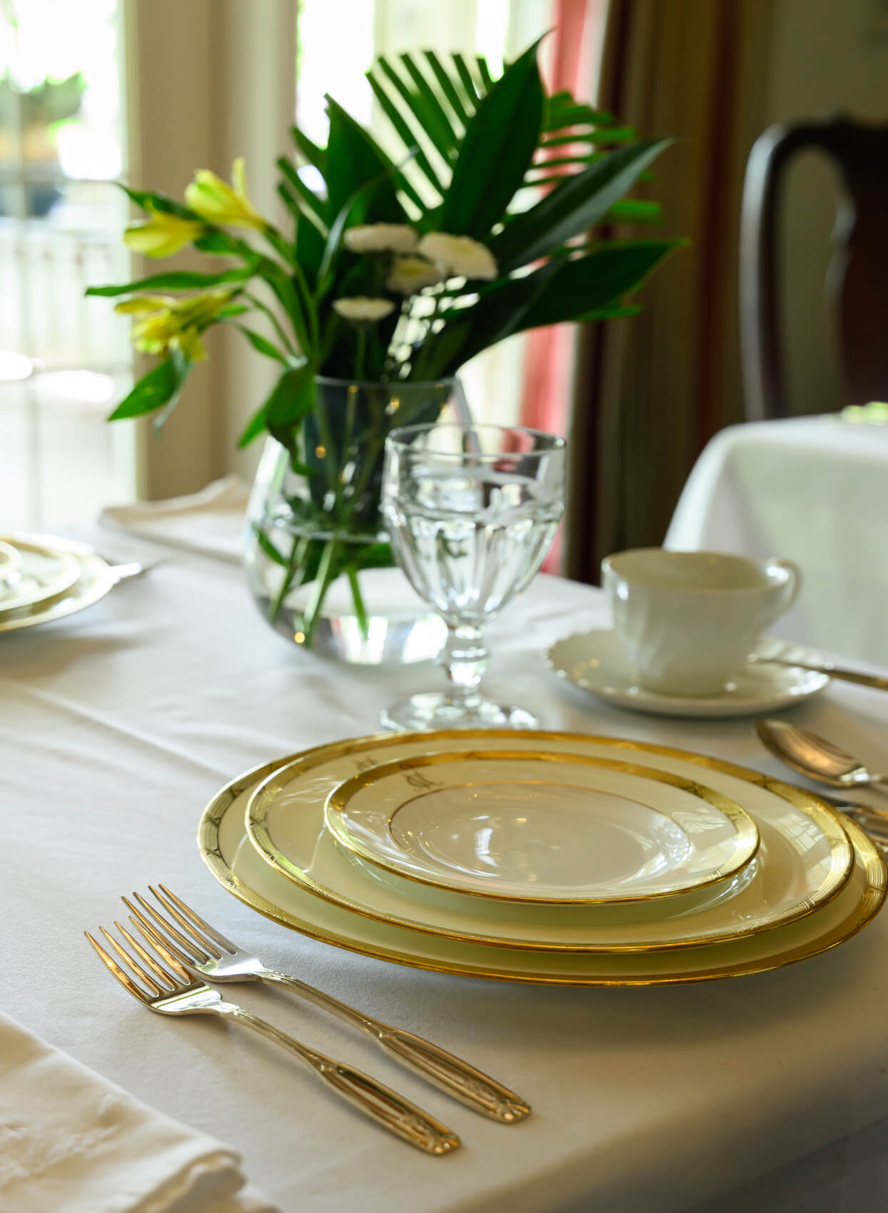 Table de salle à manger du Manoir Chamberland à Montebello avec assiettes bordées d'or